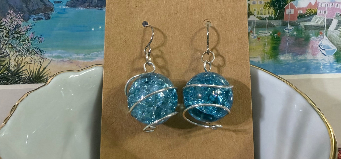 Wire-wrapped green cracked marble earrings with stainless steel ear wires  resting in a bowl displayed on a brown card.